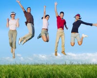 Jumping young people happy group in meadow Royalty Free Stock Photography