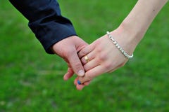 Wedding couple holding hands on grass background Royalty Free Stock Images