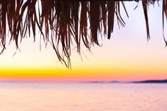 Beach umbrella close up and beach at sunset Royalty Free Stock Image