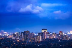 Vibrant city lit up at night beneath cloudy weather Stock Photography