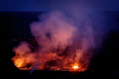 A Vibrant array of colors surround crater of active volcano glowing in the nighttime sky Stock Image